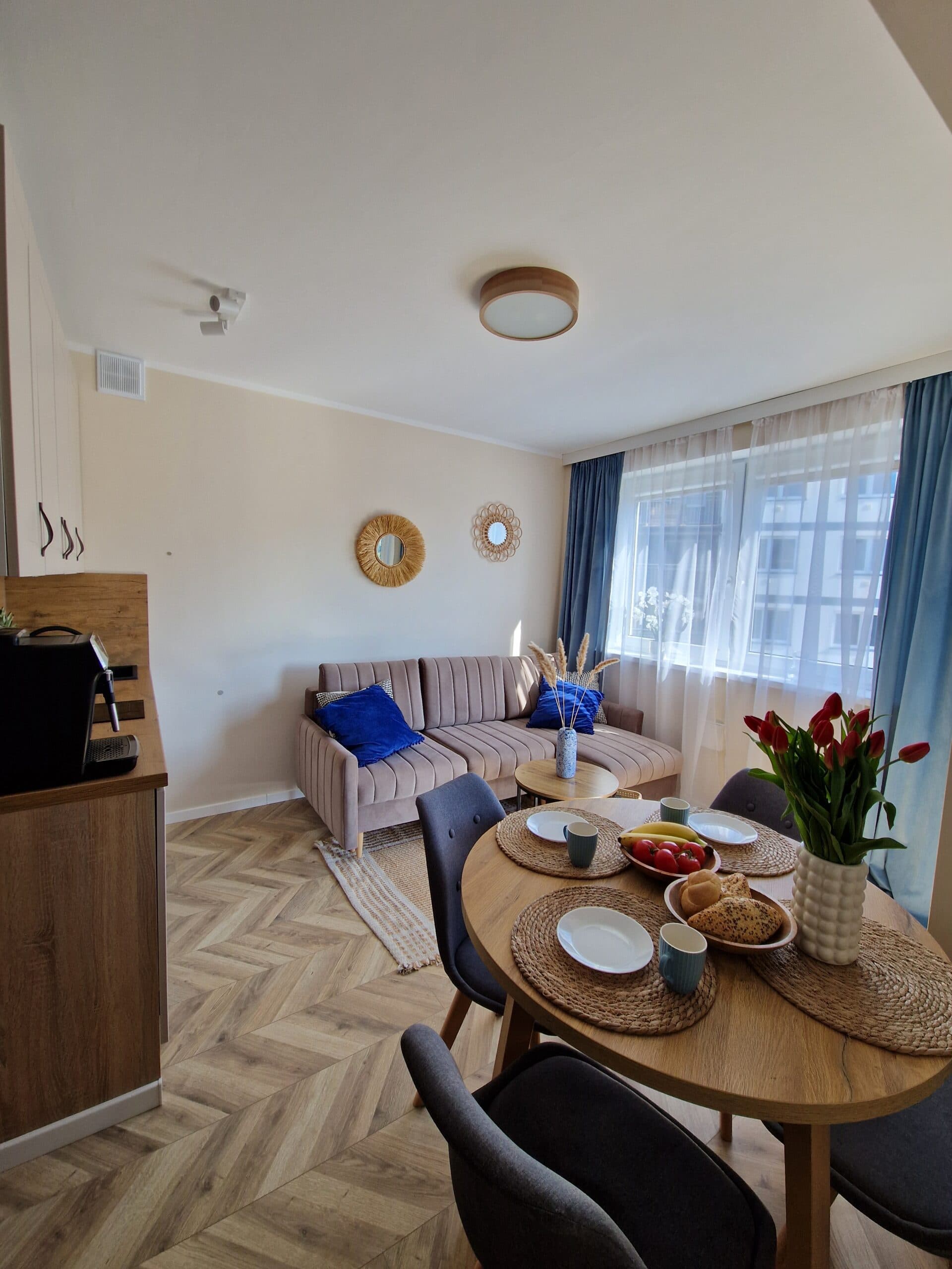 Wnętrze apartamentu w Dębinie z rattanowymi lustrami